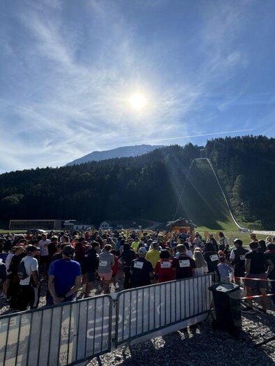 A large group of people gathers in a scenic setting. In the background, mountains and a clear sky are visible. | © Auszeit Ausseerland