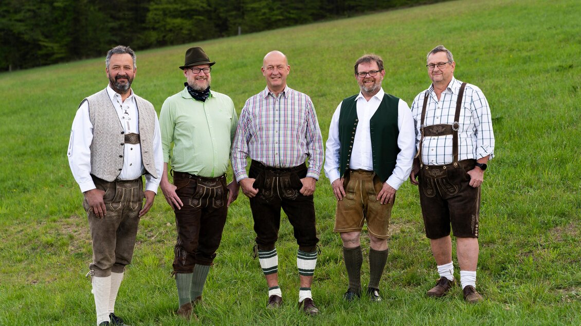 Fünf Männer in Tracht stehen auf einer Wiese beim Sänger- und Musikantentreffen und blicken in die Kamera. | © Wohlklang
