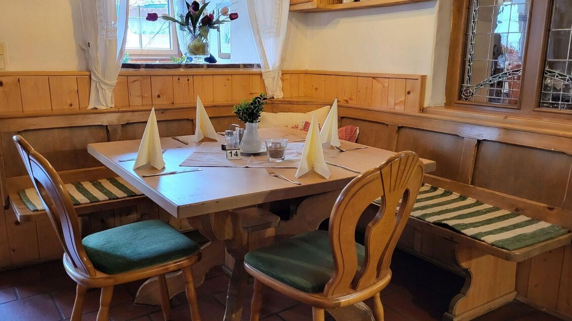 Ein gemütlicher Tisch in der gemütlichen Stube des Gasthof Berndl mit Holzverkleidung. Die Tischdekoration umfasst gefaltete Servietten und eine kleine Pflanze. | © Petra Kirchschlager