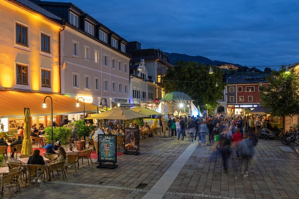 Ein belebter Platz mit gemütlichen Cafés und Restaurants bei Nacht. Viele Menschen genießen die Atmosphäre unter den Lichtern. | © Harald Steiner