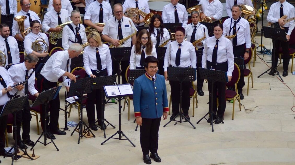 Dirigent Suyoung Ham der Blasmusikkapelle des MV Piber bei Konzert mit Musikerinnen und Musikern und Instrumenten im Innenhof. | © MV Piber
