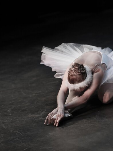 A ballet dancer in a white tutu performs an elegant pose on stage. Her facial expression shows concentration and grace. | © Pixabay