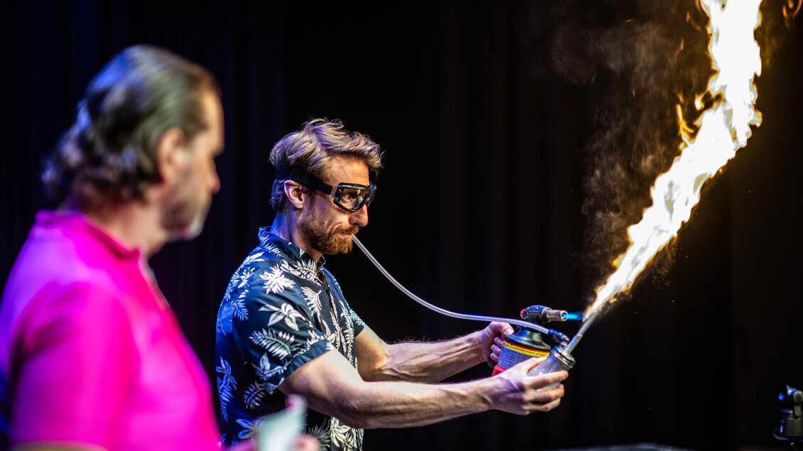Experiment der Science Busters Kids mit einer hohen Flamme auf der Bühne der Helmut-List-Halle in Graz. | © Julian Poschl