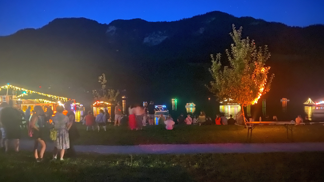 <p>Eine festliche Szene am Grundlsee beim Seefest bei Nacht mit bunten Lichtern. Menschen genießen die entspannte Atmosphäre am Wasser.</p> | © Bettina Scheck