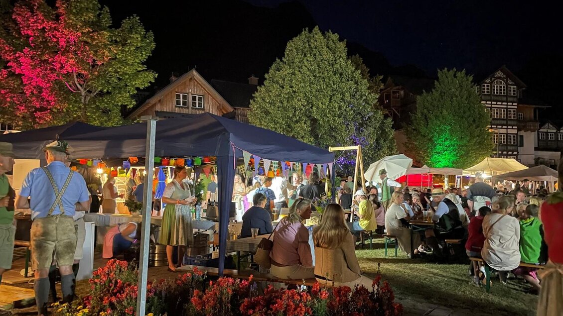Ein lebhaftes Fest mit vielen Menschen in einer festlichen Atmosphäre. Bunte Lichter und Stände schaffen eine einladende Stimmung. | © Bettina Scheck