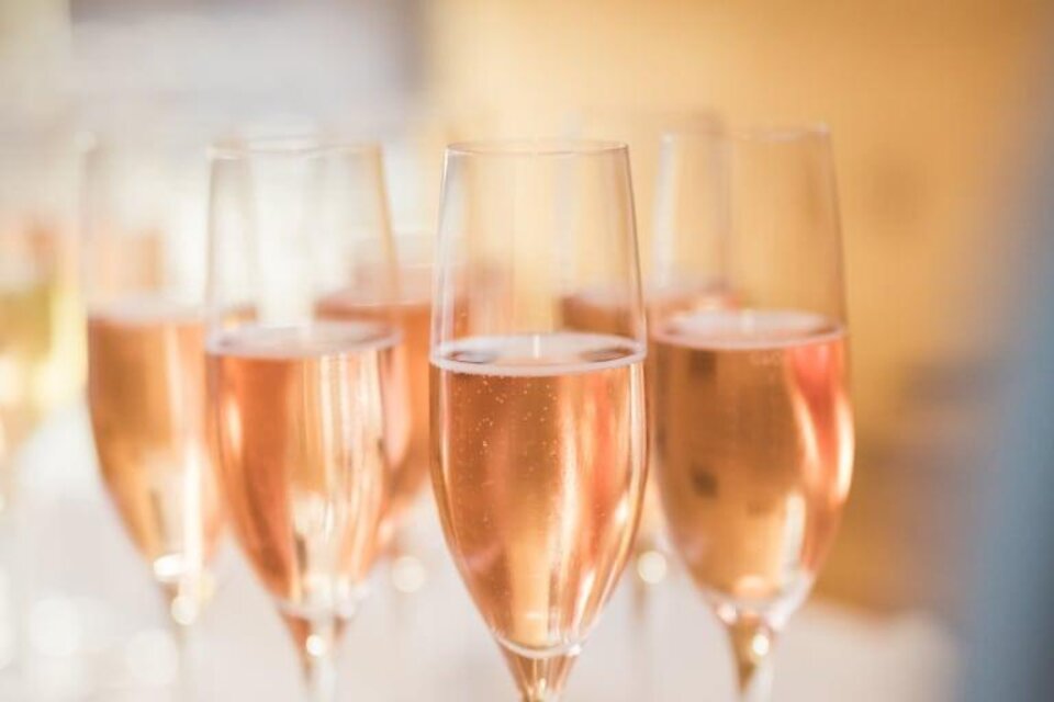 Eine Reihe von Gläsern mit rosé Champagner steht auf einem Tisch. Die Blasen im Getränk funkeln im Licht. | © Garten Hotel Ochensberger