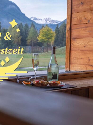 The inscription "Sole, Moon & Autumn Time" on a picture of the sauna world of the Narzissen Vital Resorts with a view of the landscape of Ausseerland Salzkammergut. | © Thomas Lahnsteiner