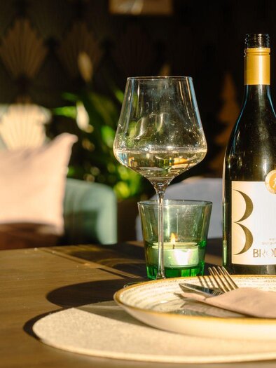 A beautiful setting at Franz Wein und Genuss restauran in Bad Aussee with a bottle of white wine in a cozy atmosphere. | © Elisabeth Pichler