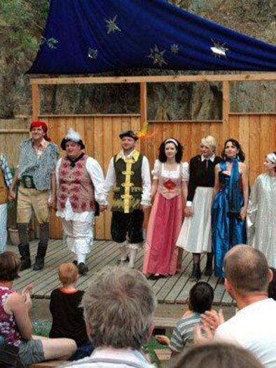 A group of actors is standing on a stage and presenting a theater performance. The audience is watching eagerly and applauding. | © Kulturverein "Die Thalburger"