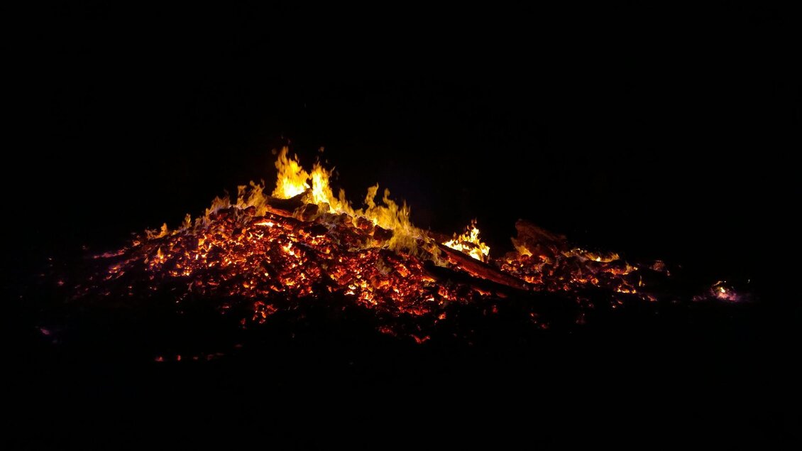 Ein Lagerfeuer leuchtet im Dunkeln. Glühende Kohlen und Flammen sind sichtbar. | © Pixabay