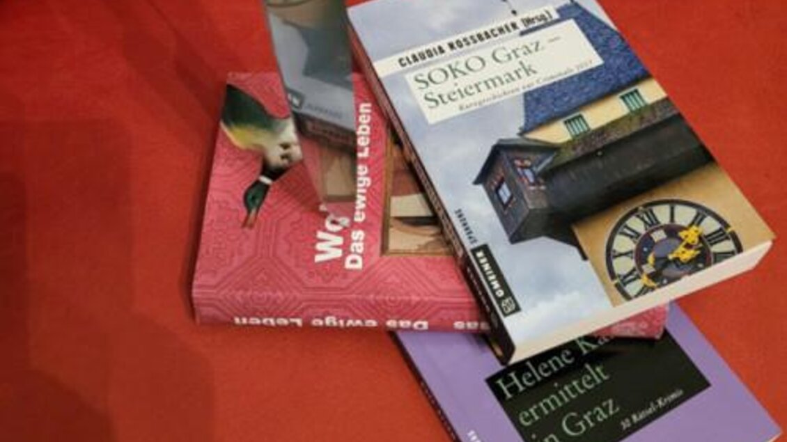 Bücher zu Kriminalfällen in Graz auf rotem Untergrund, Thema Krimi-Führung. | © GrazGuides