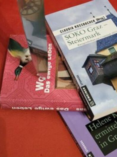 Books on criminal cases in Graz on a red background, theme crime tour. | © GrazGuides