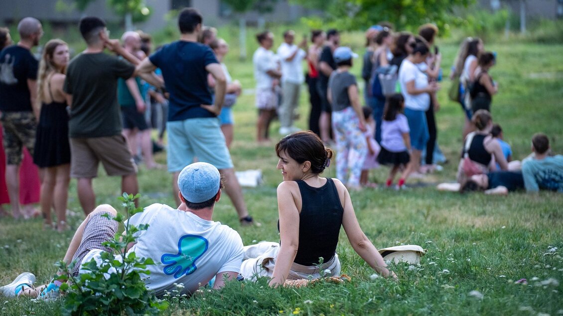 Besucher sitzen und stehen auf einer Wiese beim Stadtteilfest Reininghaus in Graz. | © Peter Hutter