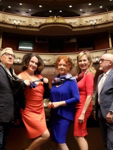 Eine Gruppe von fünf Personen steht in einem eleganten Theater. Sie tragen bunte Kleidung und posieren mit fröhlichen Gesichtern. | © Helmut Fladenhofer