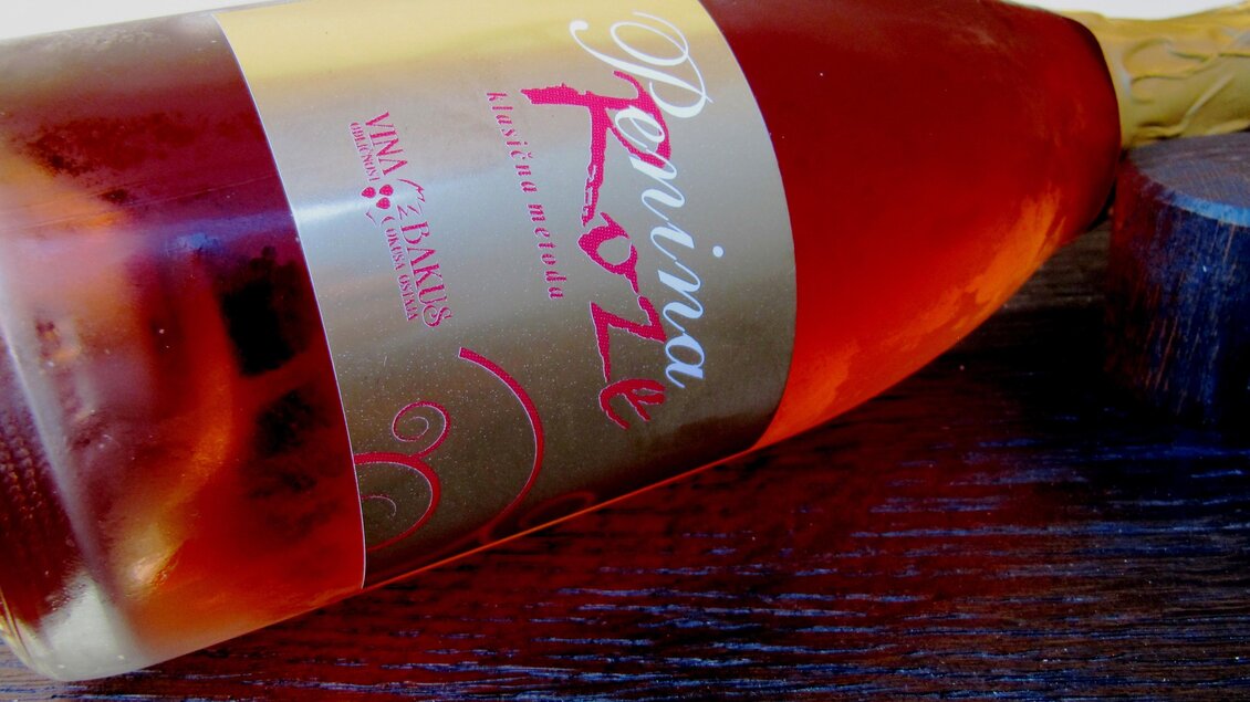 Eine Flasche Roséwein liegt auf einem dunklen Holztisch. Etikett und Flasche sind ansprechend gestaltet. | © Vladi Slodnjak