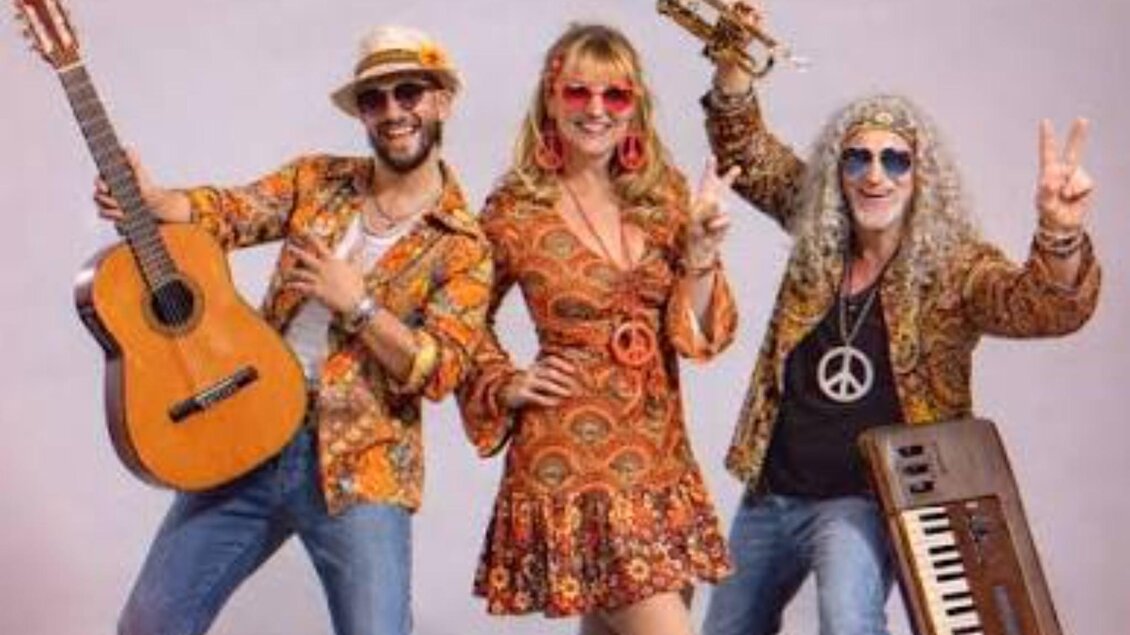 Band Music Deluxe in farbenfrohen Retro-Outfits mit Gitarre, Trompete und Keyboard beim Stattegger Kultursommer. | © musicdeluxe.at