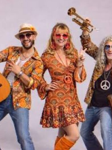 Band Music Deluxe in colorful retro outfits with guitar, trumpet, and keyboard at the Stattegger Cultural Summer. | © musicdeluxe.at
