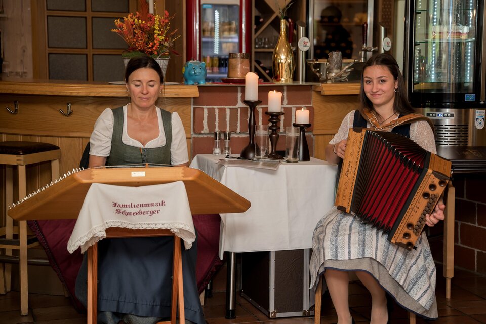 Zwei Frauen spielen traditionelle Instrumente in einem gemütlichen Lokal. Die Atmosphäre ist warm und einladend. | © Anita Fössl