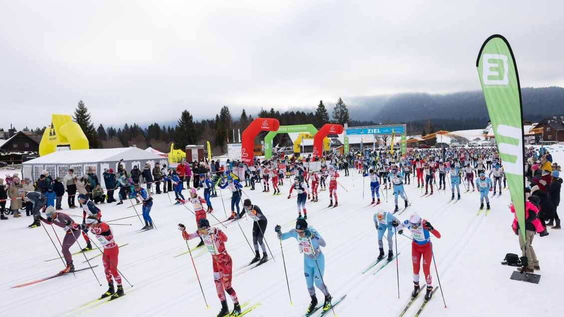 Die Läufer starten zum 30-km-Lauf in klassischer Technik und bewegen sich auf der schneebedeckten Loipe davon. Über der Strecke liegt ein bewölkter Himmel, während die guten Schneeverhältnisse für optimale Bedingungen sorgen. | © Steiralauf/Martin Huber