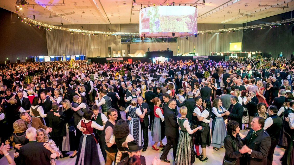 Eine große Menschenmenge tanzt in traditionellen Trachten auf einer Veranstaltung. Die Atmosphäre ist lebhaft und festlich, mit vielen Tänzern in bunten Outfits. | © Foto Fischer
