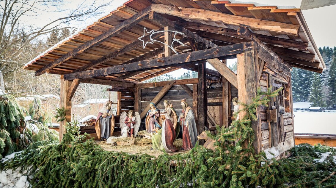 Eine traditionelle Weihnachtskrippe in einem Holzstall, umgeben von Tannenzweigen. Die Figurengruppe zeigt die Geburt Jesu im Winter. | © Naturpark Zirbitzkogel-Grebenzen, Mediadome