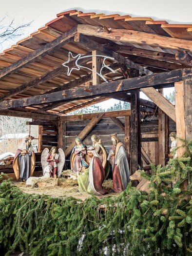 Eine traditionelle Weihnachtskrippe in einem Holzstall, umgeben von Tannenzweigen. Die Figurengruppe zeigt die Geburt Jesu im Winter. | © Naturpark Zirbitzkogel-Grebenzen, Mediadome