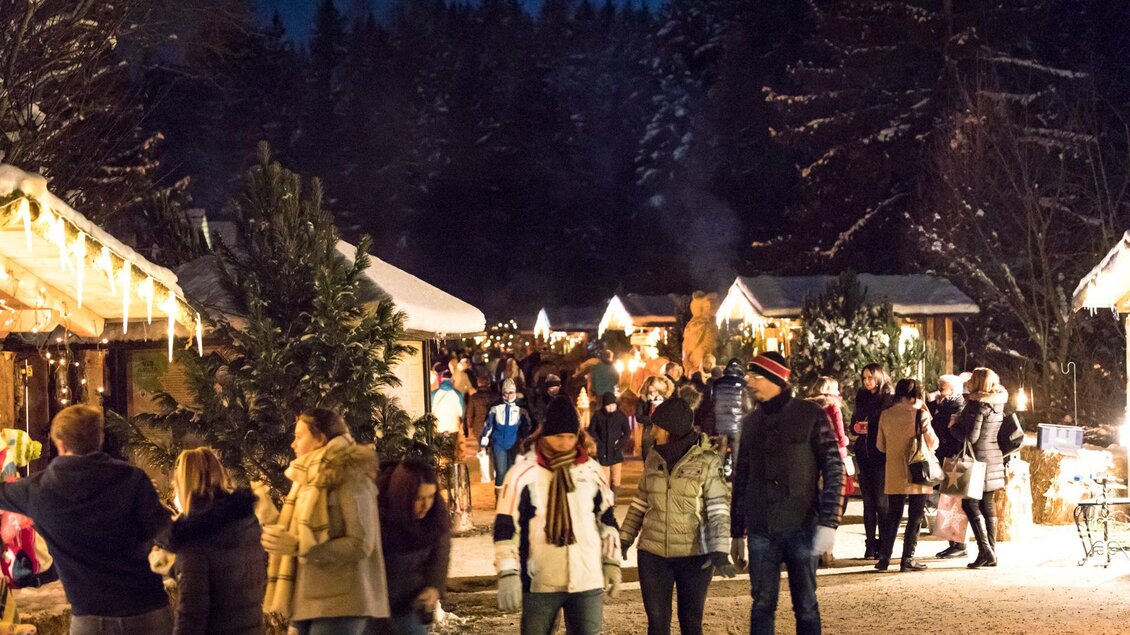 Ein festlicher Weihnachtsmarkt bei Nacht mit beleuchteten Ständen und fröhlichen Menschen. Die Atmosphäre ist warm und einladend, umgeben von winterlicher Natur. | © Naturpark Zirbitzkogel-Grebenzen, Mediadome