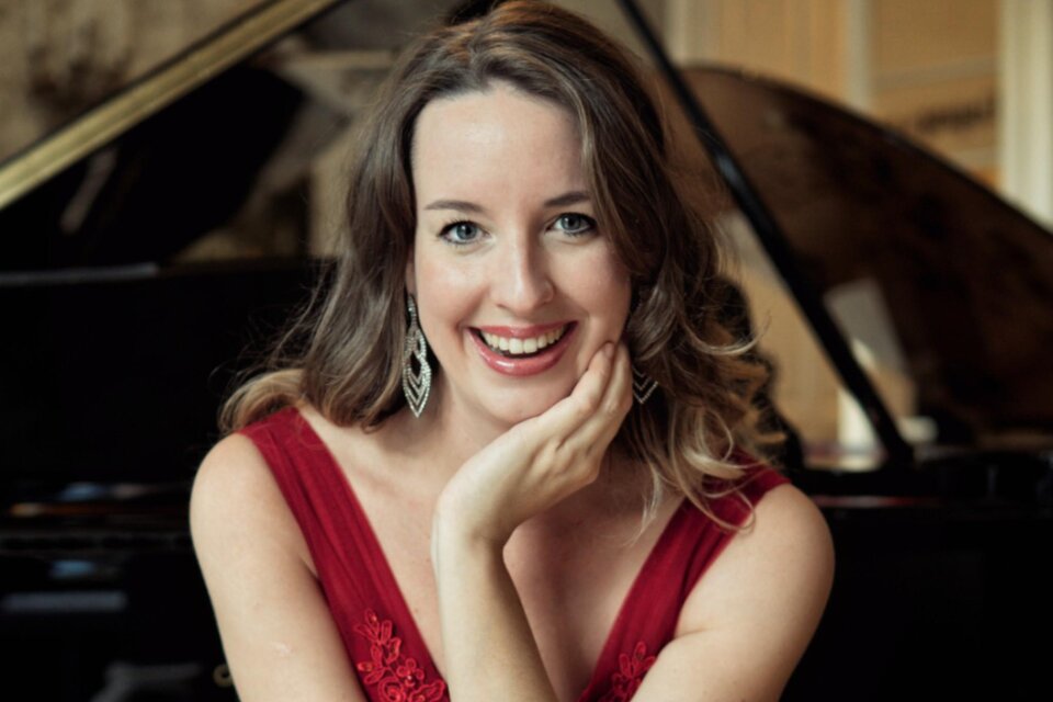 Porträt der Pianistin Irina Vaterl in rotem Kleid vor einem Flügel. | © Fortin