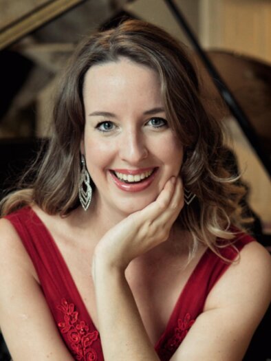 Porträt der Pianistin Irina Vaterl in rotem Kleid vor einem Flügel. | © Fortin