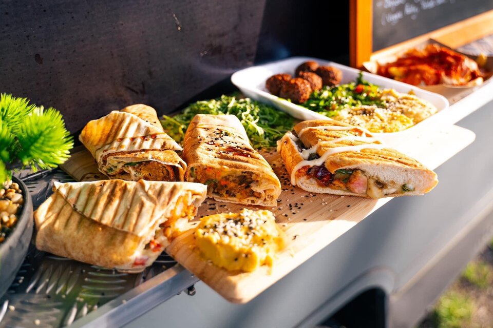 Ein Food Truck mit verschiedenen leckeren Gerichten. Es gibt gefüllte Sandwiches, frische Salate und Snacks auf einem Tisch präsentiert. | © Oststeiermark Tourismus