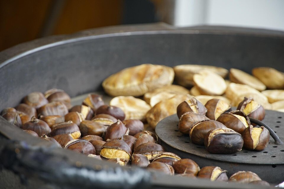 Geröstete Kastanien und gebratene Kartoffelscheiben in einer großen Pfanne. Die Oberfläche ist dunkel und weist Röstspuren auf. | © Pixabay