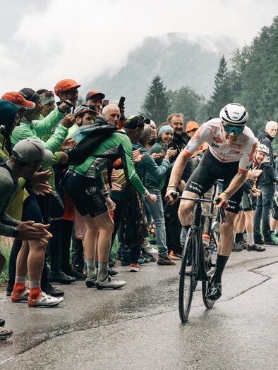 Rennradfahrer fahren einen steilen Berg in der Menge. Die Zuschauer feuern die Sportler an und es herrscht eine aufregende Atmosphäre. | © EXPA