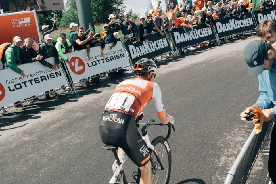 Eine Gruppe von Radfahrern fährt schnell auf einer Straße. Die Athleten tragen bunte Trikots und Helme. | © EXPA