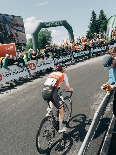 A group of cyclists is riding quickly on a road. The athletes are wearing colorful jerseys and helmets. | © EXPA