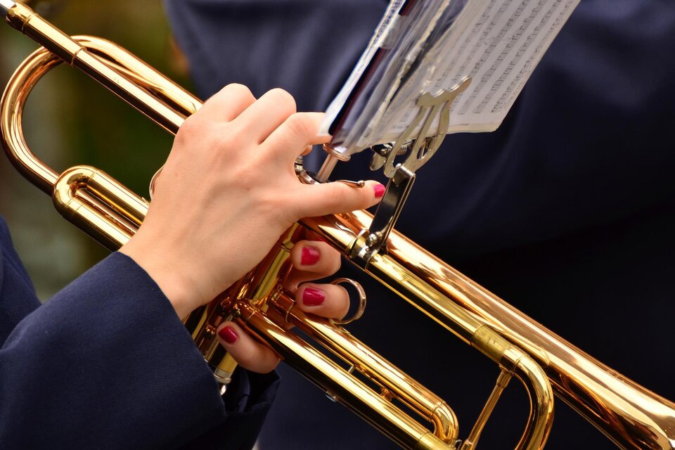 Eine Hand spielt auf einer Trompete. Die Nägel sind rot lackiert und das Instrument glänzt golden. | © pixabay