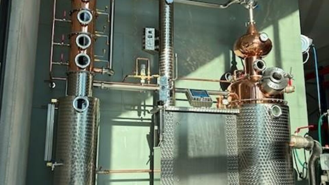 Eine moderne Destillationsanlage aus Edelstahl und Kupfer. Sie steht auf einem grauen Boden in einem gut beleuchteten Raum. | © Destillerie Fuxbau OG
