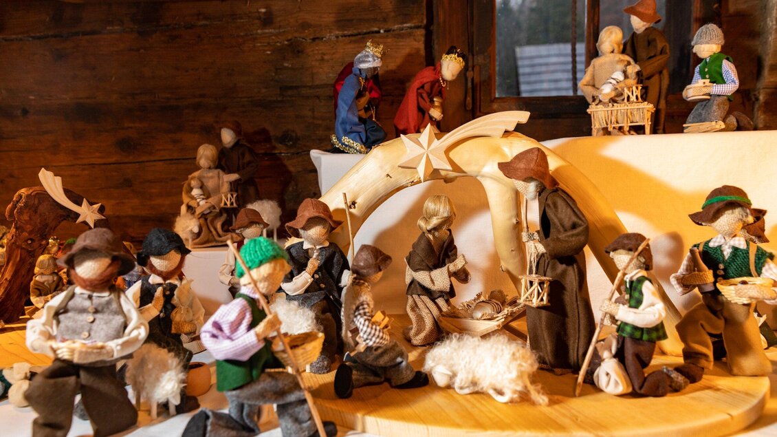 Eine Sammlung von kunstvollen Figuren, die traditionelles Handwerk darstellen. Die Figuren sind um eine dekorative Weihnachtskrippe angeordnet. | © Region Graz - Harry Schiffer