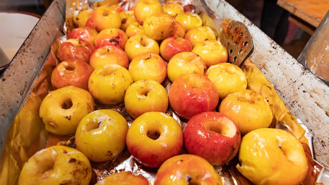 Ein Blech voller gebackener Äpfel in verschiedenen Farben. Die Äpfel haben ein goldgelbes und rotes Aussehen und sind sorgfältig angeordnet. | © Region Graz - Harry Schiffer