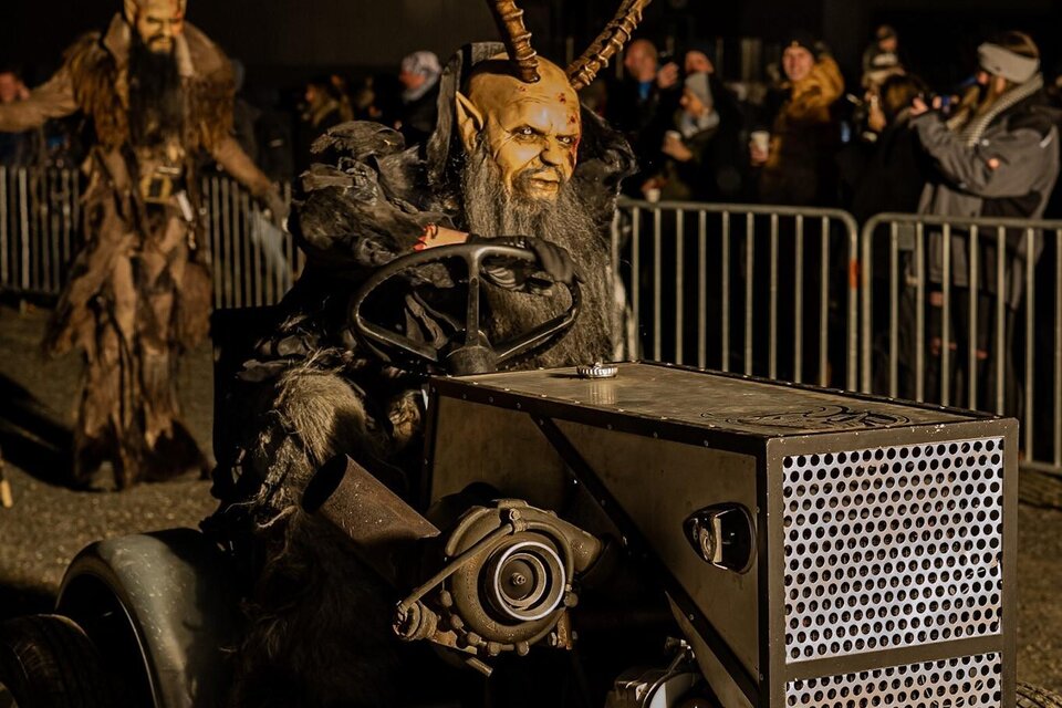 Eine kreative Parade mit Menschen in Kostümen und Masken, die auf einem Traktor fahren. Im Hintergrund sind viele Zuschauer zu sehen. | © Tv Murau