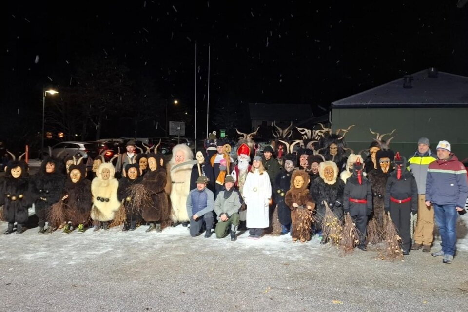 <p>Die Kinderkrampusgruppe in traditionellen Kostümen und Masken steht im Freien bei Nacht.</p> | © Roman Gruber