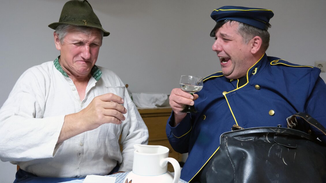 Zwei Darsteller stoßen in einer Szene aus dem Theaterstück „Wenn da Kuckuck zwoamol schreit“ in Hirschegg-Pack an. | © Theatergruppe Pack