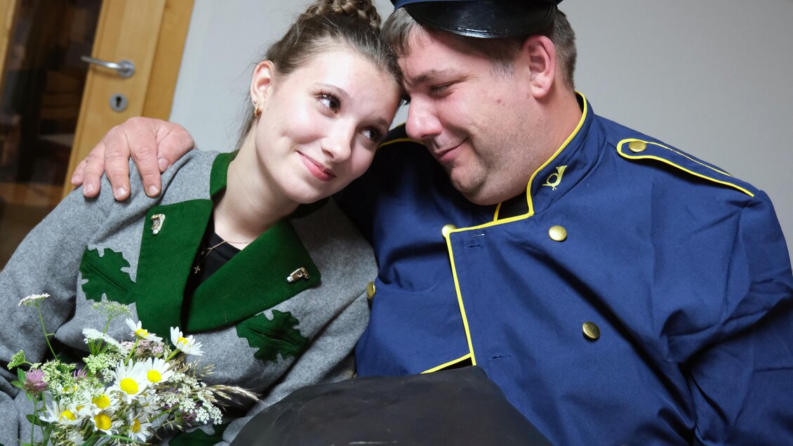 Darsteller als Postbote und junge Frau in einer Szene aus dem Theaterstück „Wenn da Kuckuck zwoamol schreit“ in Hirschegg-Pack. | © Theatergruppe Pack
