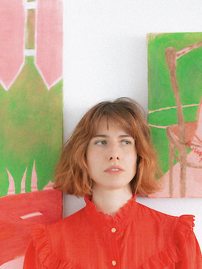 Artist Theresa Obermayer in a red blouse in front of two large-format, colorful paintings in an exhibition. | © Luca Celine Mueller