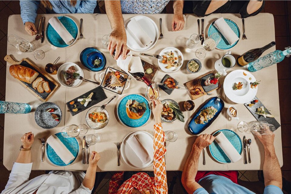 Ein gedeckter Tisch mit verschiedenen Gerichten und Getränken. Menschen sitzen zusammen und genießen eine gemeinsame Mahlzeit. | © Tischlein deck dich_Oststeiermark
