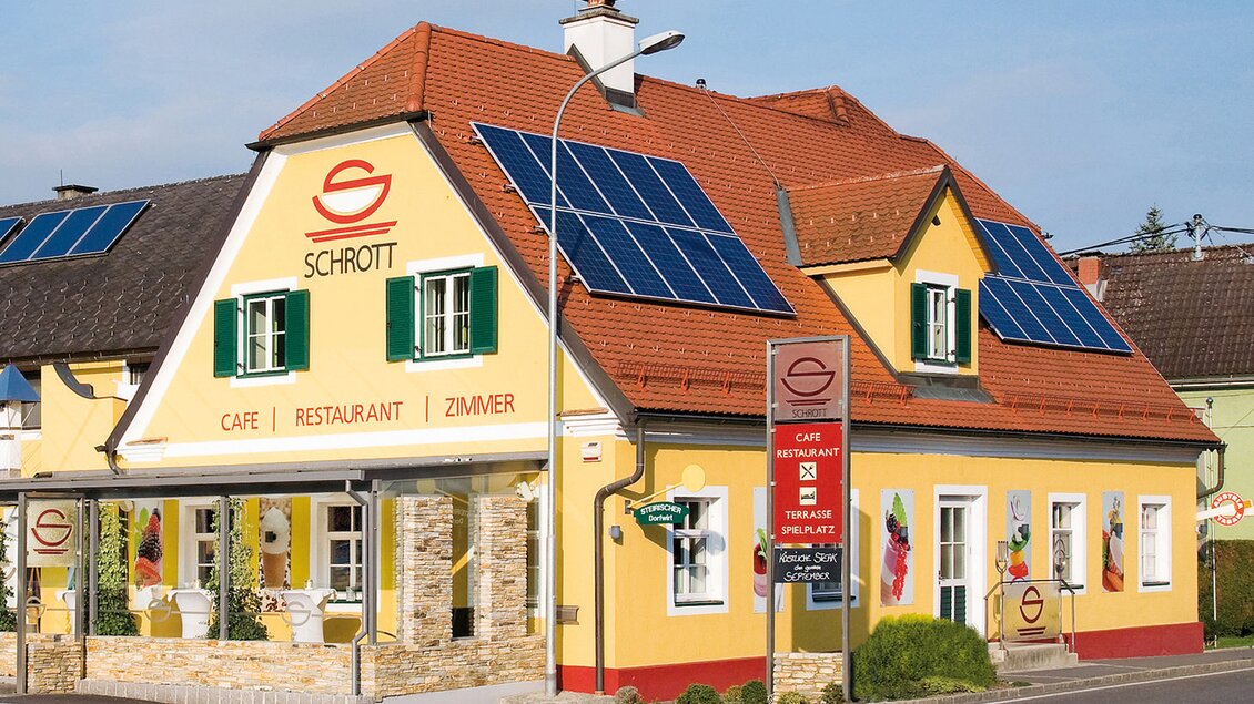 Ein charmantes Gebäude mit einer bunten Fassade. Es beherbergt ein Café und ein Restaurant und hat Solarzellen auf dem Dach. | © Restaurant Schrott_Oststeiermark