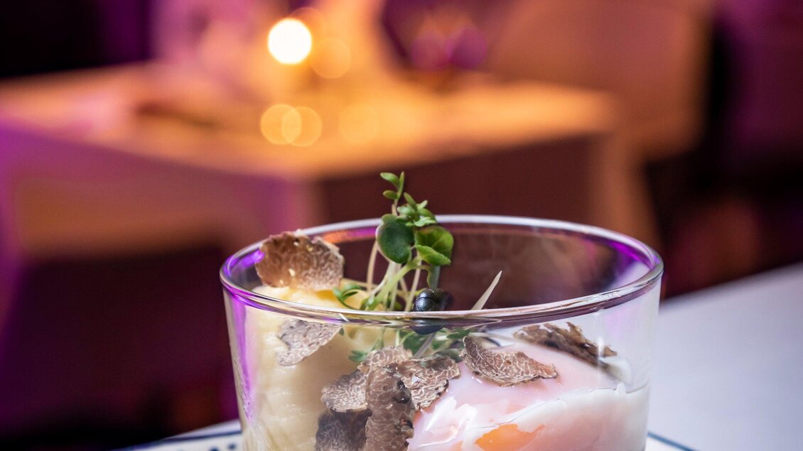Ein stilvolles Dessert in einem Glas mit verschiedenen Schichten und einer dekorativen Garnitur. Das Gericht wirkt elegant und ansprechend, ideal für feine Anlässe. | © Graz Tourismus - Werner Krug