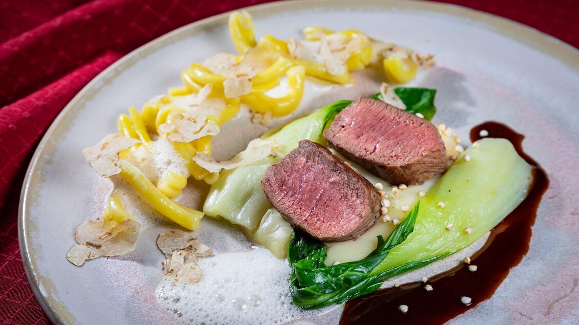 Ein kunstvoll angerichteter Teller mit zartem Fleisch, Gemüse und Pasta. Die Speise ist elegant dekoriert und wirkt sehr appetitlich. | © Graz Tourismus - Werner Krug