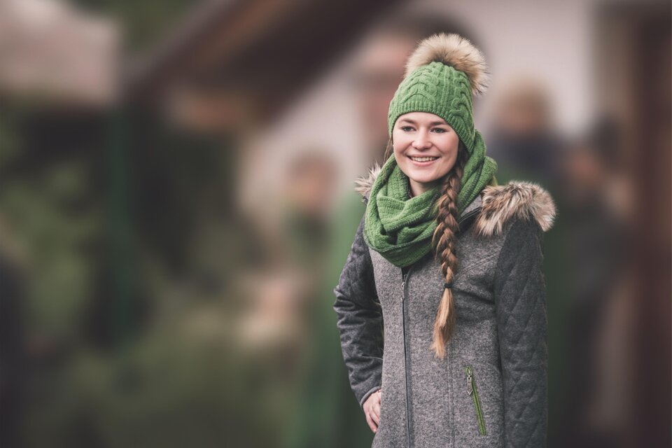 Ein roter Stern aus geflochtenem Material liegt auf grünen Tannenzweigen. Um ihn herum sind rote Weihnachtskugeln dekoriert. | © Karin Ziegler