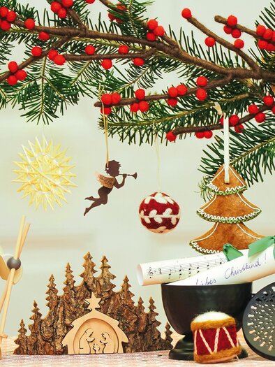 Ein festlich geschmückter Weihnachtsbaum mit buntem Schmuck und zweigen. Verschiedene Weihnachtsfiguren und Dekorationen ergänzen die festliche Atmosphäre. | © vkstmk