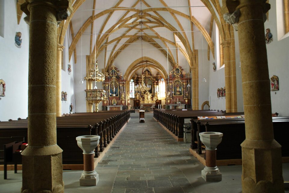 Eine schöne Kirche mit hohen Gewölben und Holzsäulen. Der Blick führt zum Altar, umgeben von kunstvollen Verzierungen. | © Markus Paar